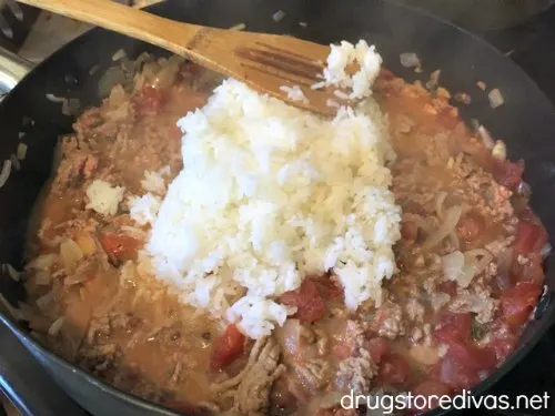 Onions, garlic, diced tomatoes, ground turkey, and rice in a pan.