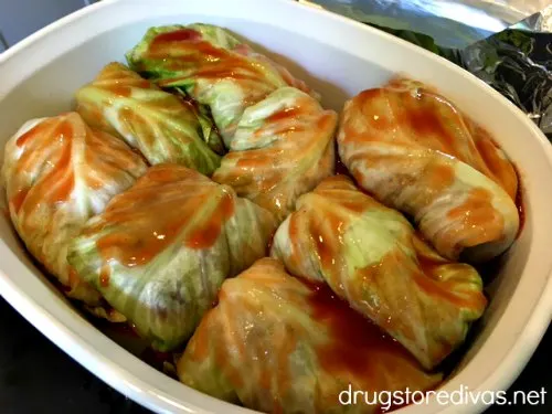 Tomato juice poured on top of stuffed cabbage rolls in a casserole pan.