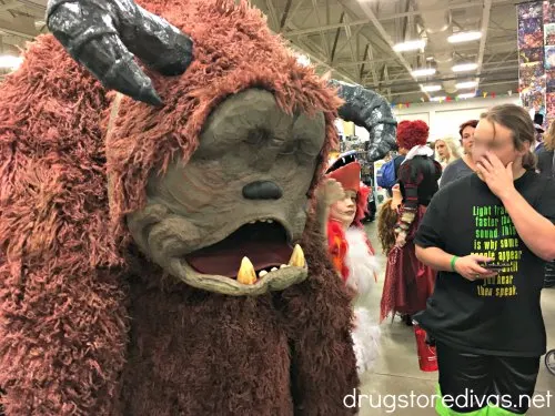 A man looking at someone dressed as Ludo from the movie Labyrinth.