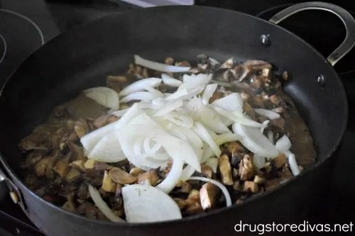 Chopped mushrooms and sliced onions in a pan.