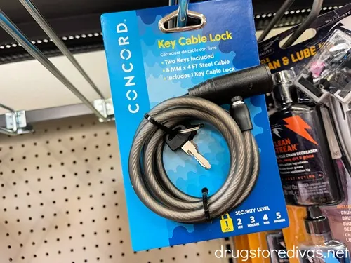 A bike lock in a package on a peg in a store.