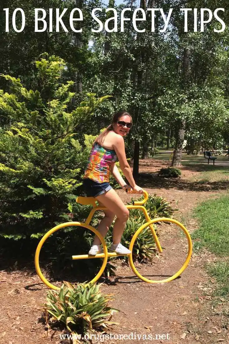 A woman riding a fake yellow bike in a park with the words 