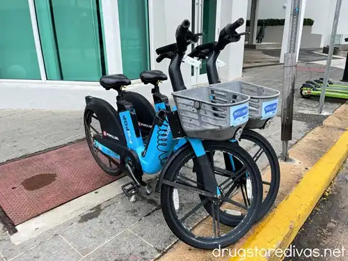 Two bikes on a sidewalk.
