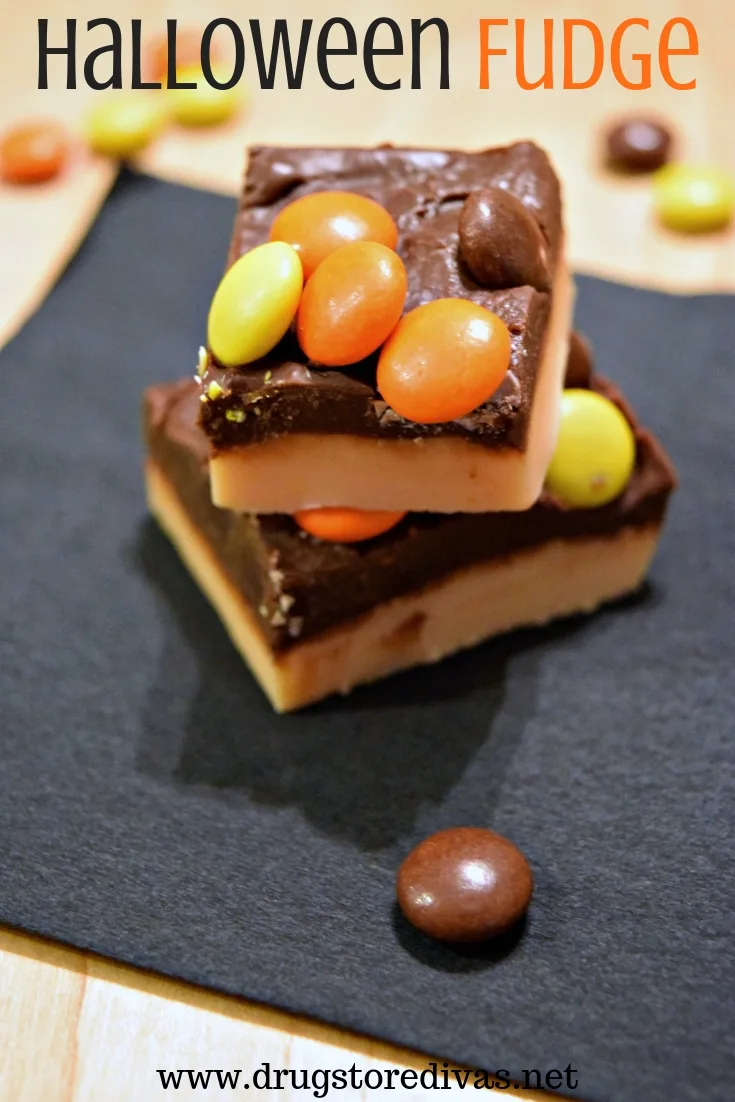 Two pieces of black and orange fudge on top of a black napkin, with Reese's Pieces, around and the words "Halloween Fudge" digitally written on top.