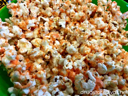 Popcorn in a bowl, covered with melted orange candy melts.