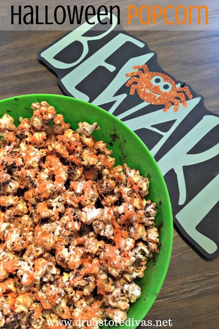 Halloween popcorn in a bowl, next to a Halloween sign that says "Beware" and the words "Halloween Popcorn are digitally written on top.