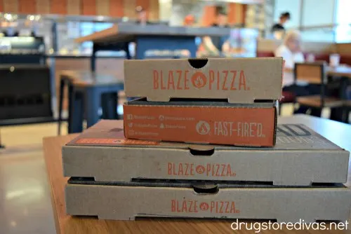Four Blaze Pizza boxes stacked on a table.