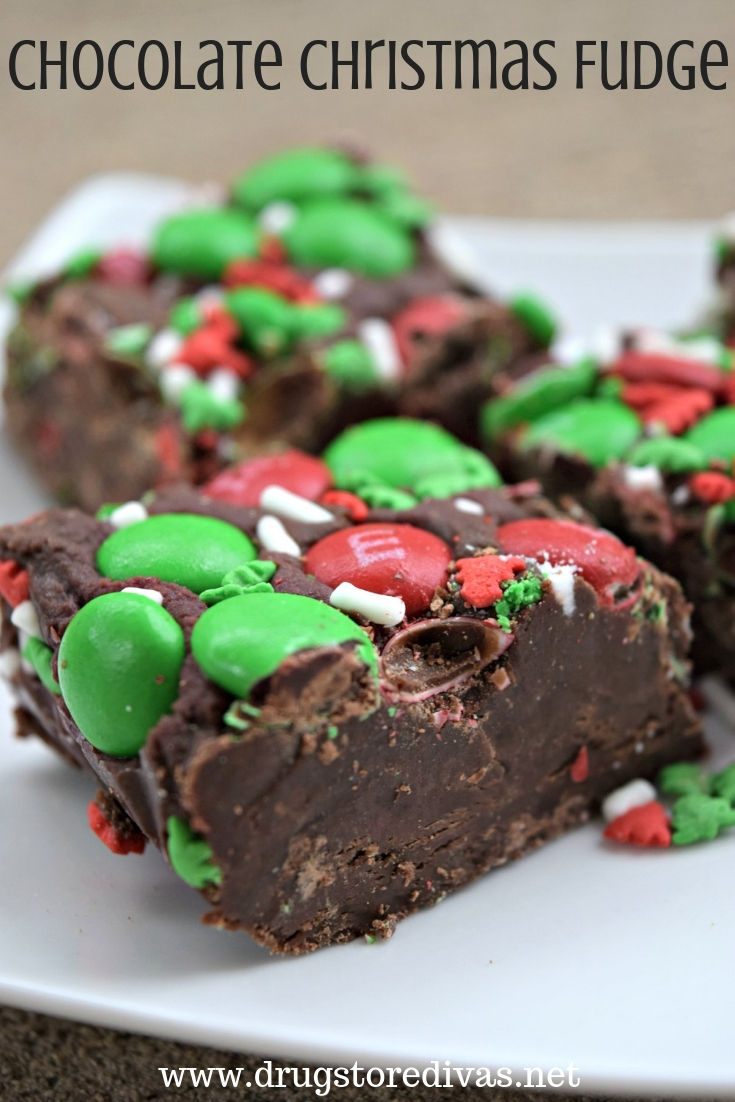 Pieces of chocolate fudge with red and green M&M candies and white sprinkles on top with the words 