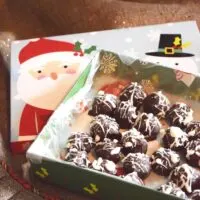 Homemade truffles in a Christmas box under a Christmas tree with the words 