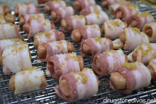 Bacon-wrapped cocktail wieners with brown sugar on top on a wire rack.