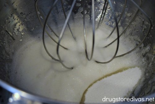 Fluffy egg whites and sugar in a stand mixer.