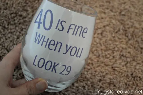 Need a gift for a 40th birthday party? Make these DIY 40 Is Fine When You Look 29 Glitter Wine Glass. Get the tutorial and printable on www.drugstoredivas.net.