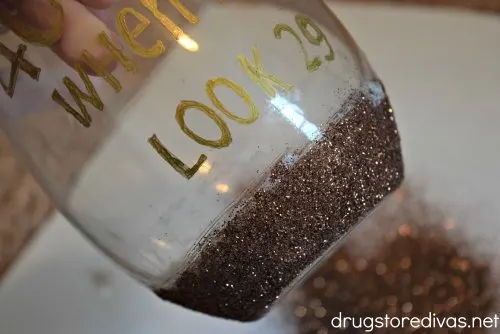 Need a gift for a 40th birthday party? Make these DIY 40 Is Fine When You Look 29 Glitter Wine Glass. Get the tutorial and printable on www.drugstoredivas.net.