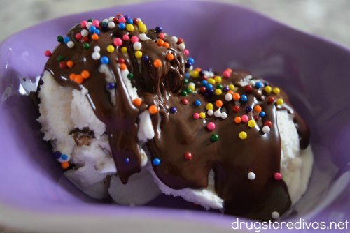 Magic shell and sprinkles on ice cream in a purple bowl.