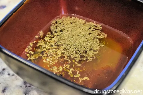 Oil with seasoning on top in a red bowl.