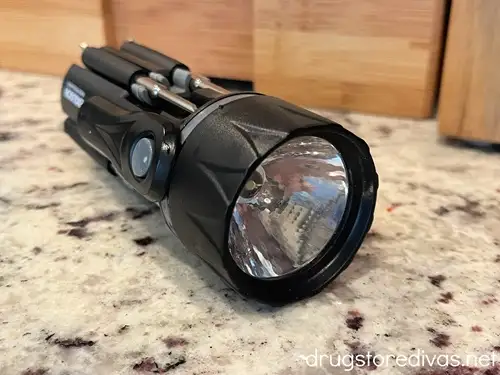 A black flashlight on a kitchen counter.