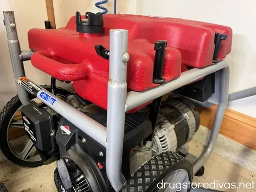 A red generator in the corner of a garage.