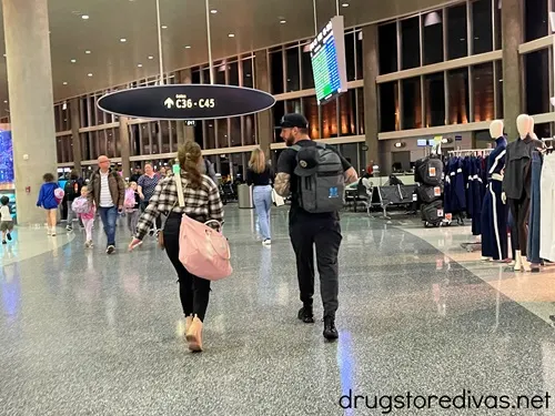 Two people walking in an airport terminal.