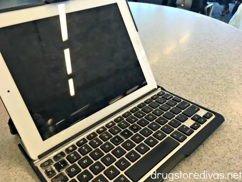 An iPad with keyboard on a table at an airport.