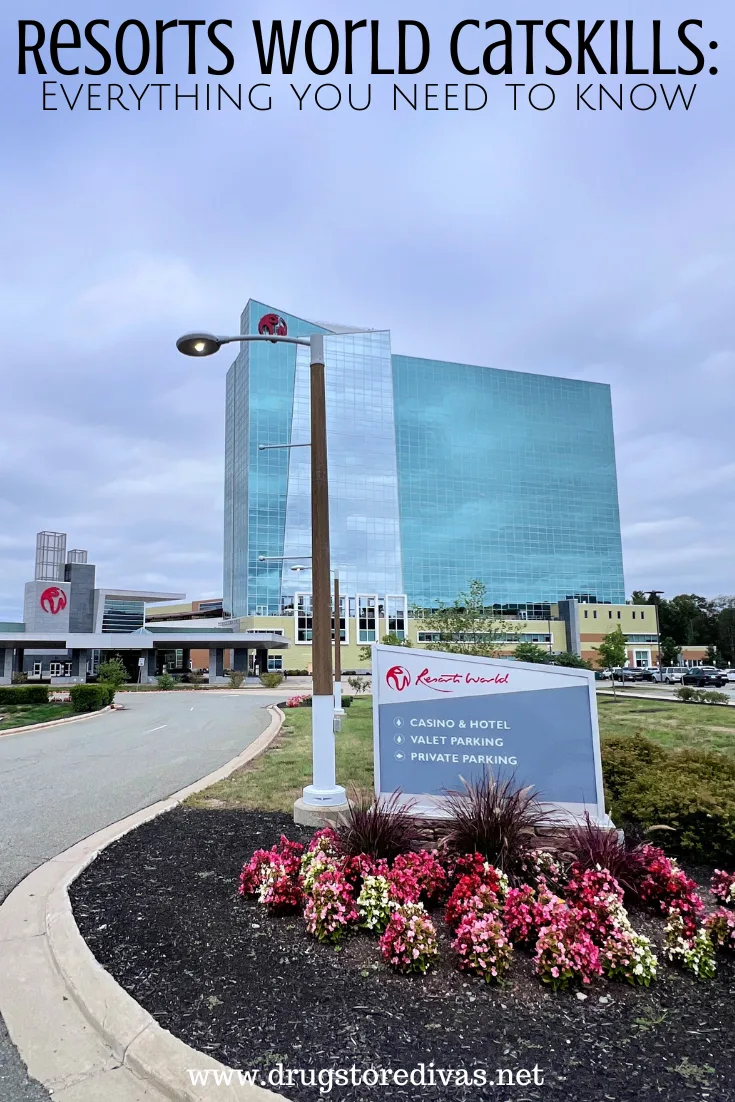 A glass building in the back and a sign with directions in the foreground with the words 