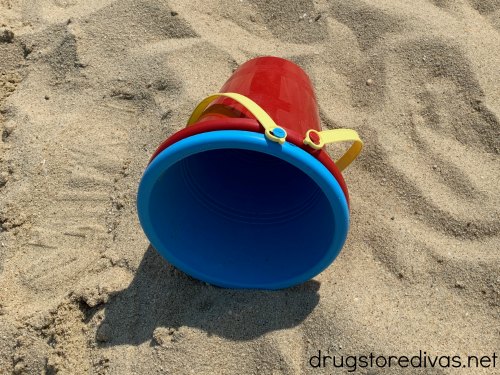 A beach bucket in the sand.