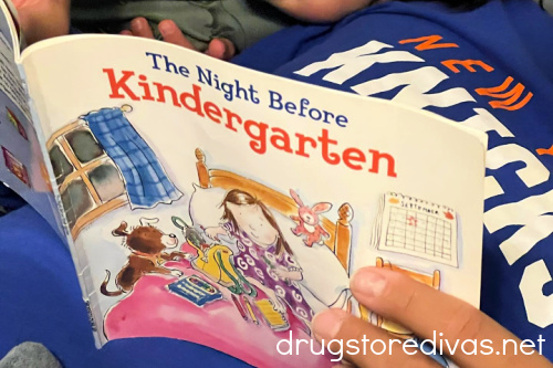 The Night Before Kindergarten book opened by a man's hand.
