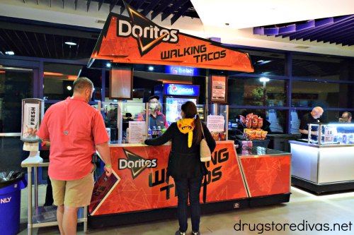 Two people waiting on line at a kiosk selling Doritos Walking Tacos at the Crown Complex in Fayetteville, North Carolina.
