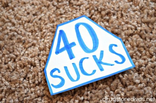 A trapezoid-shaped piece of paper that says, "40 Sucks."