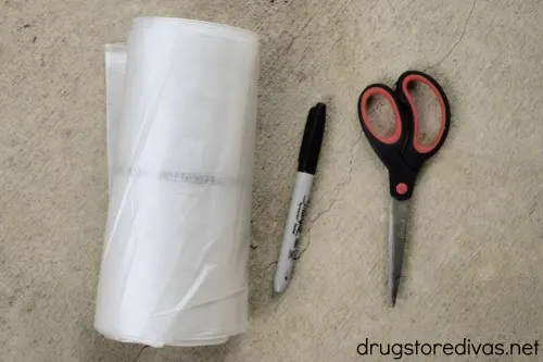 A roll of white garbage bags, a black marker, and scissors.