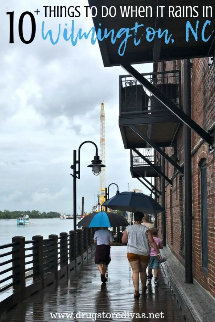 Four people, carrying umbrellas, walking on the riverwalk in Wilmington, NC with the words "10+ Things To Do When It Rains In Wilmington, NC" digitally written on top.