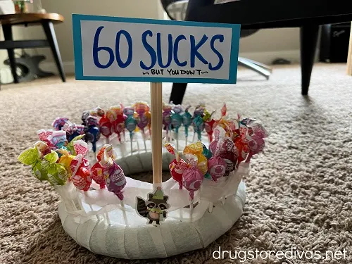 A lollipop tower with a sign on top that says "60 Sucks But You Don't".
