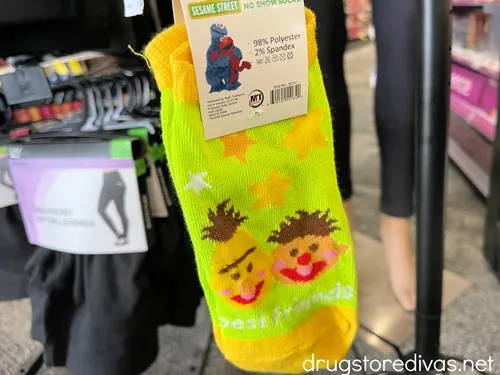 A neon green pair of socks with Bert and Ernie from Sesame Street's faces on it.