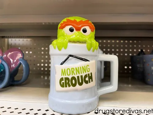 A 3D Oscar the Grouch mug on a shelf in a store.