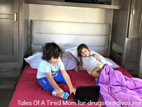 Two kids on a bed in an RV.