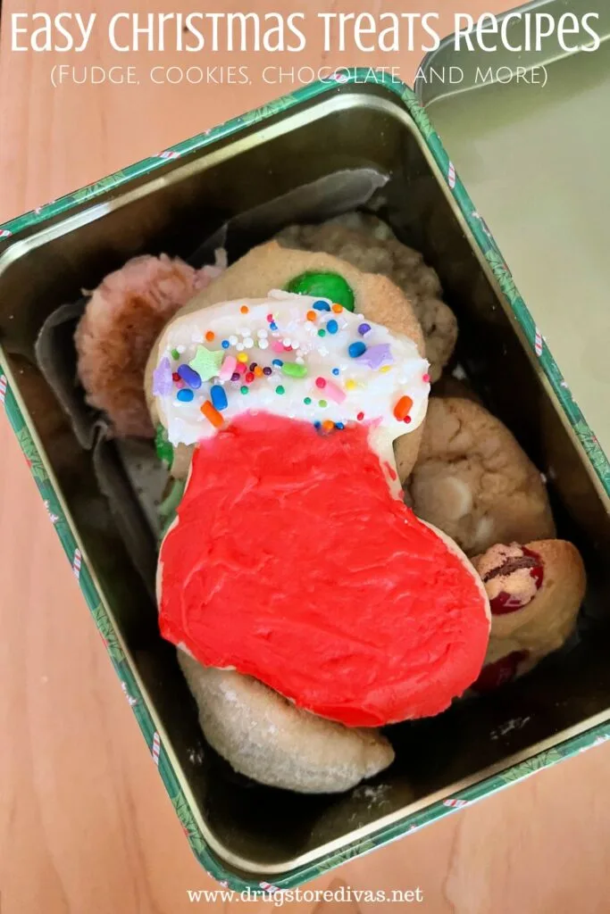A Christmas stocking-shaped cookie on top of other cookies in a tin on a table with the words "Easy Christmas Treats Recipes (fudge, cookies, chocolate, and more)" digitally written on top.