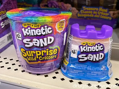 Two containers of Kinetic Sand on a shelf.