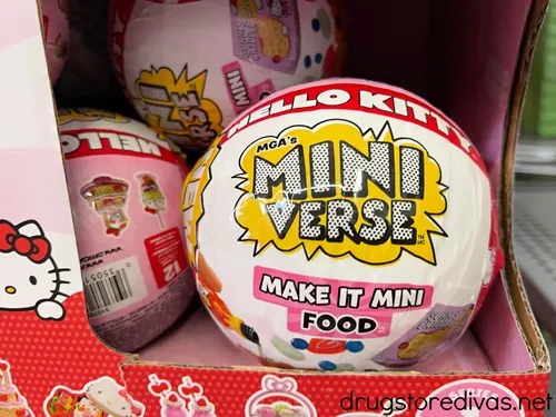 A colorful ball that says Mini Verse on it in a display on a shelf.