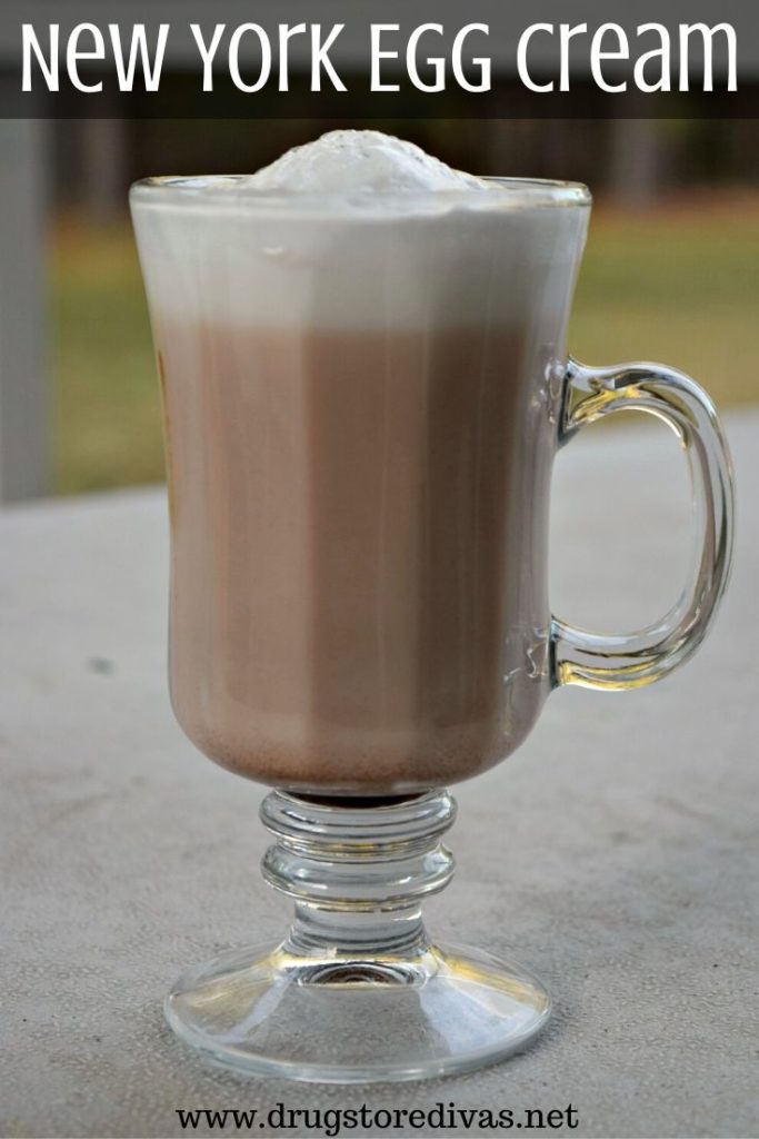 Glass with a brown drink and white foam on top.