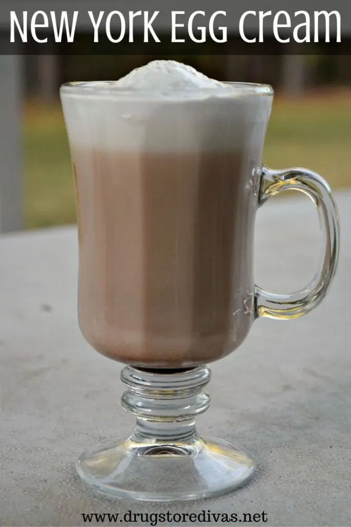 Glass with a brown drink and white foam on top.
