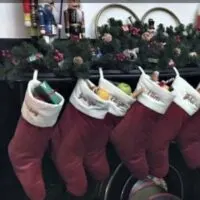 Six stockings hanging on a mantle with the words 