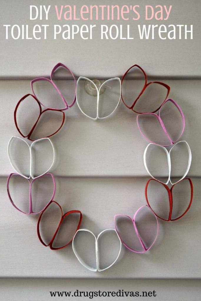 Toilet paper rolls folded into heart shapes with the words "DIY Valentine's Day Toilet Paper Roll Wreath" digitally written on top.