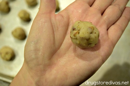 Handing holding a cookie dough ball.