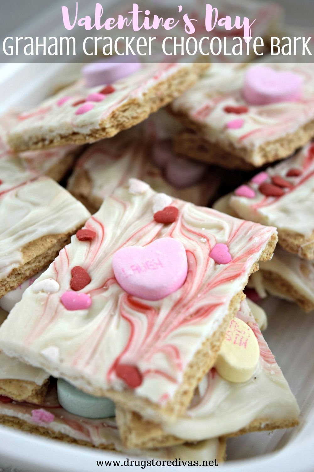 White and red candy bark on top of a graham cracker with heart candies in it and the words "Valentine's Day Graham Cracker Chocolate Bark" digitally written on top.