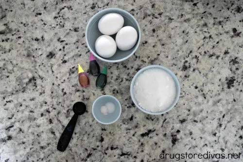 Eggs, food coloring, sugar, seasoning on a countertop.