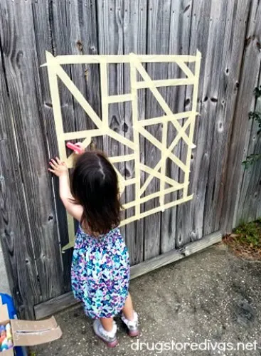 Looking for a fun outdoor kids activity? This Masking Tape And Chalk Mural Craft is perfect. Get details at www.drugstoredivas.net.