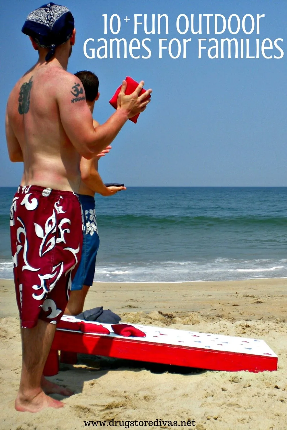 Two men at the beach playing cornhole with the words 
