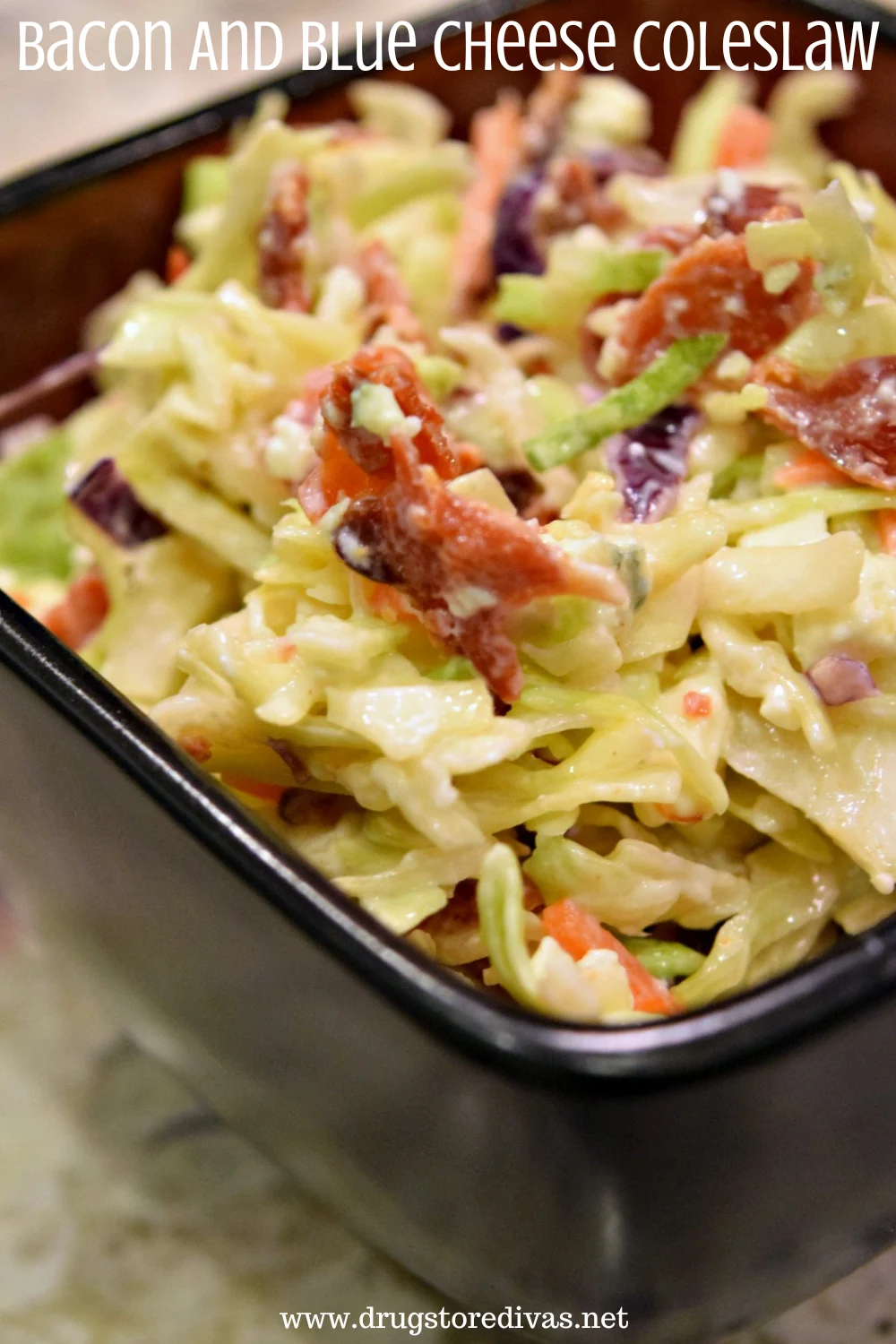 Cabbage, bacon, and a crumbled cheese in a black, square bowl with the words 