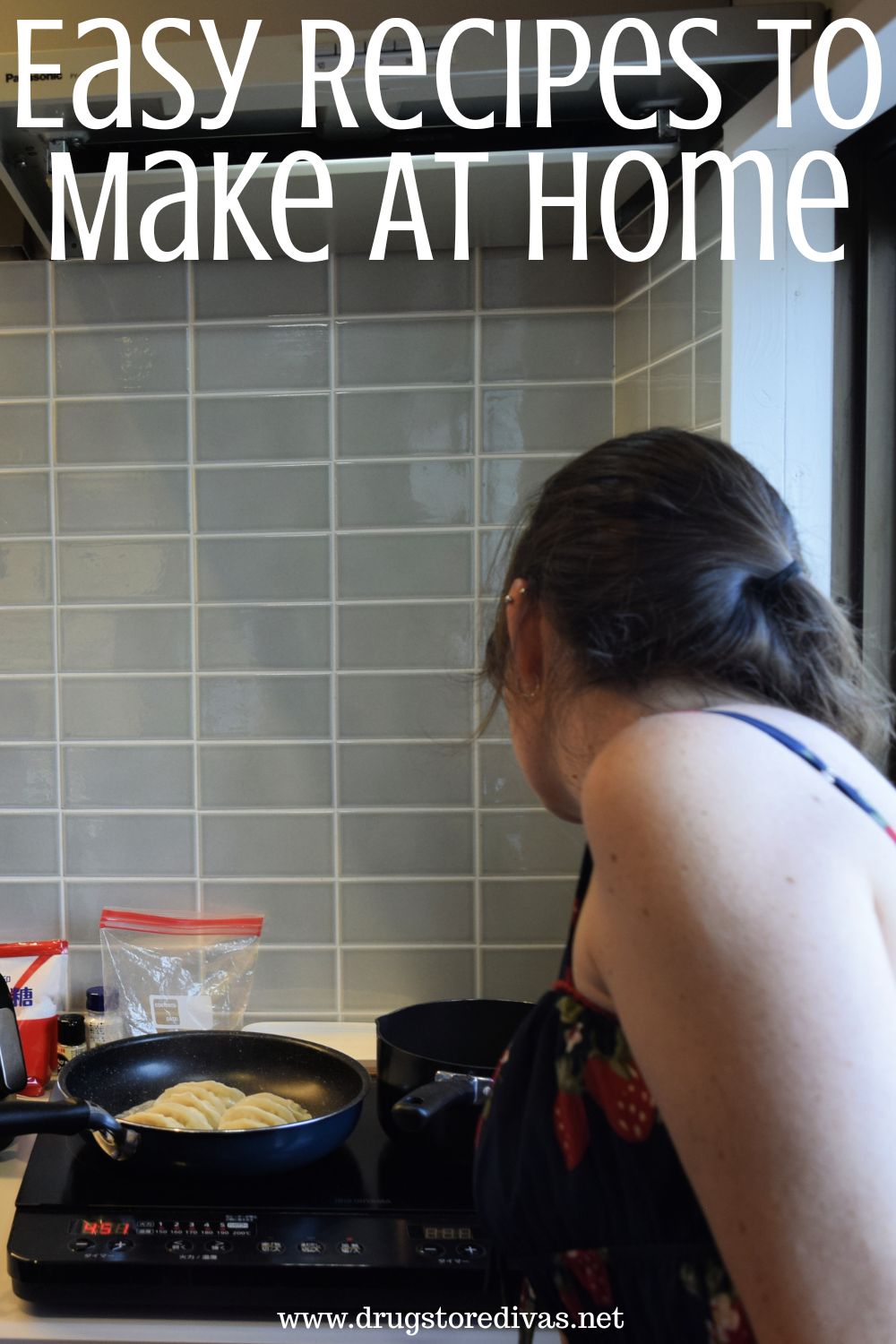 A woman in a dress looking over a stove where a pan of gyoza is cooking with the words 