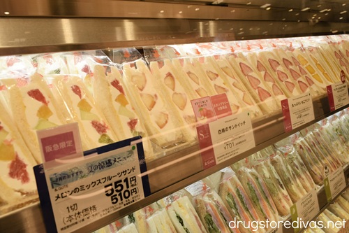 A shelf filled with Japanese fruit sandwiches about a shelf filled with other Japanese sandwiches.