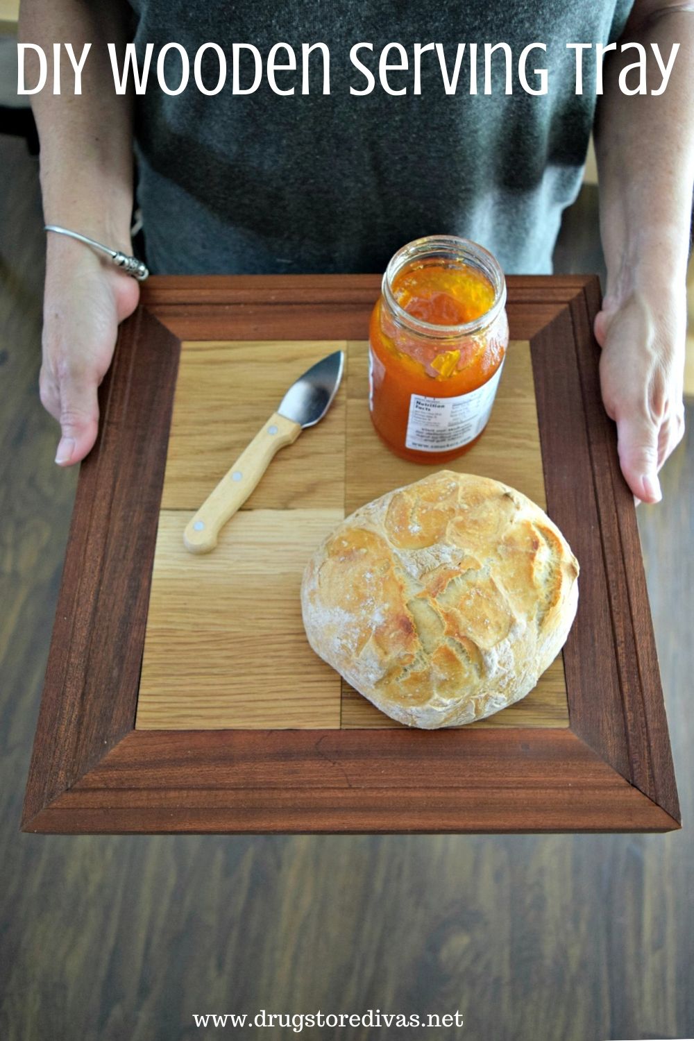 A woman holding a serving tray with bread and jelly on it and the words "DIY Wooden Serving Tray" digitally written on top.